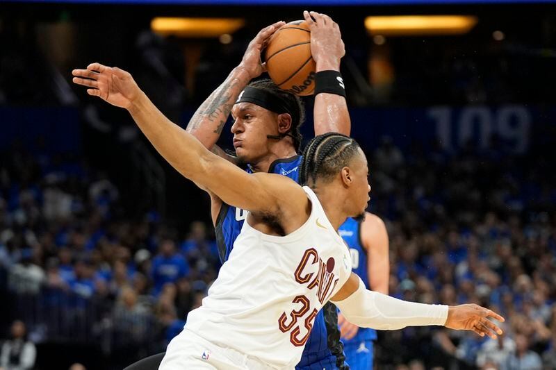 Orlando Magic forward Paolo Banchero, back, makes a moves to go around Cleveland Cavaliers forward Isaac Okoro (35) during the second half of Game 6 of an NBA basketball first-round playoff series, Friday, May 3, 2024, in Orlando, Fla. (AP Photo/John Raoux)