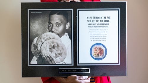 Deborah Evans poses with a picture of her late husband, chef Darryl Evans, at her home in Stone Mountain on Thursday, February 15, 2024. (Arvin Temkar / arvin.temkar@ajc.com)