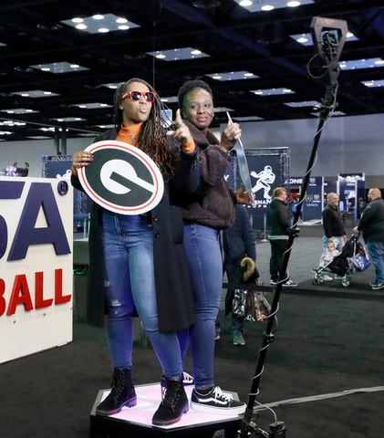 Brittany Jordan (left) and Arielle Jordan, a former UGA student, have fun at the 3d photo booth at Fan Central in the Indiana Convention Center at the 2022 College Football Playoff National Championship  between the Georgia Bulldogs and the Alabama Crimson Tide at Lucas Oil Stadium in Indianapolis on Saturday, January 8, 2022.   Bob Andres / robert.andres@ajc.com