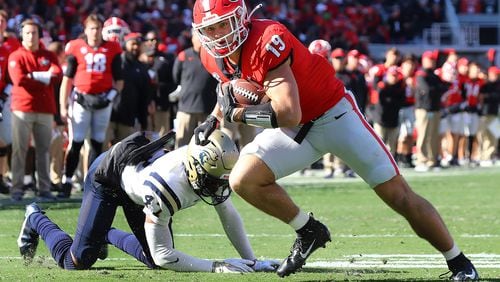 Georgia tight end Brock Bowers (19) makes a 4-yard touchdown reception past fallen Charleston Southern defensive back Kamron Smith during the first quarter at Sanford Stadium on Saturday, Nov. 20, 2021, in Athens, Georgia. (Curtis Compton/Atlanta Journal-Constitution/TNS)