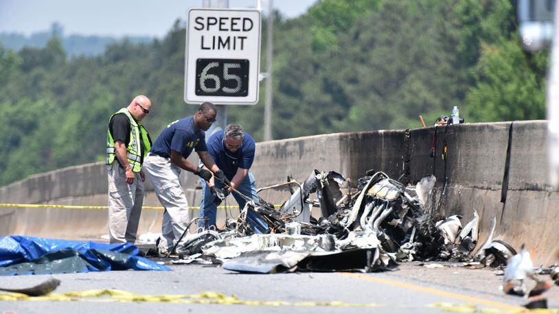 May 8, 2015 Atlanta - NTSB Safety Investigator Eric Alleyne (center) and other officials investigate on I-285 at Peachtree Industrial Boulevard, where four people died aboard a small plan on Friday, May 8, 2015. Traffic was shut down in both directions. Three men and one woman were killed in the crash, according to Channel 2 Action News. The National Transportation Safety Board is in charge of the investigation and will determine probable cause. HYOSUB SHIN / HSHIN@AJC.COM