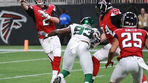 Falcons quarterback Matt Ryan dumps off a pass to running back Ito Smith under pressure from New York Jets linebacker Tarell Basham.   Curtis Compton/ccompton@ajc.com