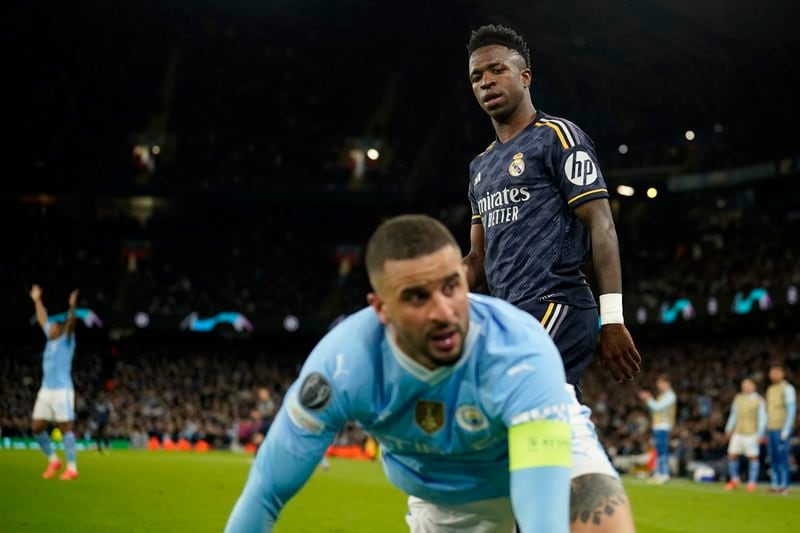Manchester City's Kyle Walker falls next to Real Madrid's Vinicius Junior during the Champions League quarterfinal second leg soccer match between Manchester City and Real Madrid at the Etihad Stadium in Manchester, England, Wednesday, April 17, 2024. (AP Photo/Dave Thompson)