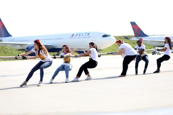 Members of the "Take the Thech Ops Girls Power “ team pull the 757 airplane as hard as possible during the fundraising Relay for Life and Jet Drag event on Wednesday, May 4. 2022. Miguel Martinez / miguel.martinezjimenez@ajc.com