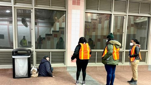 Volunteers conducting the annual point-in-time count of homeless people in Atlanta interact with Jerry Young at MARTA's Buckhead Station. (Photo by Bill Torpy)