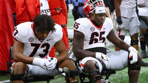 Georgia offensive lineman Xavier Truss (left) and Amarius Mims sit dejected and stunned on the sidelines in the final minutes of a 41-24 loss to Alabama in the SEC Championship game on Saturday, Dec 4, 2021, in Atlanta.   “Curtis Compton / Curtis.Compton@ajc.com”`