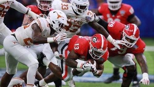 Jan. 01, 2019 New Orleans: Texas defenders bring down Georgia tailback Elijah Holyfield for short yardage during the first half in the Allstate Sugar Bowl at Mercedes-Benz Superdome on Tuesday,  Jan. 1, 2019, in New Orleans.    Curtis Compton/ccompton@ajc.com