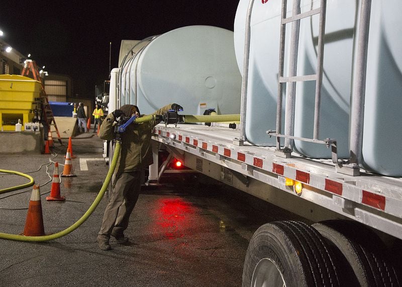 Paul Schuster loaded brine into two 2,500-gallon tanks on a flat bed trailer as GDOT crews prepare for distribution on the roads Tuesday morning. The forecast calls for the morning rain to possibly turn into snow. (Photo by Phil Skinner)