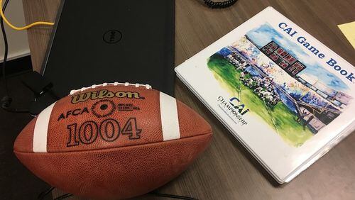 A CAI Game Book lies on a desk at Fordham University in New York, Thursday, Aug. 3, 2017. When it comes to NCAA college football in-game strategy, a six-year-old company named Championship Analytics, Inc., is quickly making a mark. CAI has gone from three schools subscribing to its service in 2014 to 53 this year, including 38 FBS teams. Using a patented system of statistical analysis, CAI provides its clients each week with a game book, a three-ring binder stuffed with pages of color-coded charts and a by-the-numbers breakdown of the matchup. Taking strengths and weaknesses of each team into account, the game book lays out possible scenarios and gives strategic recommendations based on which option provides the best odds of winning. (AP Photo/Ralph Russo)
