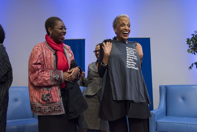 Johnnetta Betsch Cole (right), holding up a t-shirt with the names of all of Spelman''s former  Presidents from Sophia B. Packard to Mary Schmidt Campbell. Cole was the school's first Black women president after a century of leadership by white women and Black men. Dr. Helene Gayle is the current president. Julie Yarbrough Photography