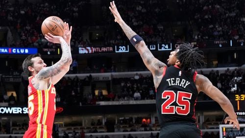 Atlanta Hawks guard Garrison Mathews, left, shoots against Chicago Bulls forward Dalen Terry during the first half of an NBA basketball game in Chicago, Monday, April 1, 2024. (AP Photo/Nam Y. Huh)