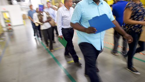 Job seekers tour the Amazon Fulfillment Center during an Amazon jobs fair on August 2, 2017 in Robbinsville, New Jersey. The American commerce company is hosting 'Amazon Jobs Day' with job fairs across the country to hire 50,000 positions for their fulfillment centers nationwide. The more than 1 million square foot facility holds tens of millions of products and features more than 14 miles of conveyor belts, employing more than 4,000 workers who pick, pack, and ship orders.