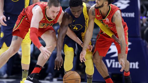 Indiana Pacers guard Victor Oladipo, center, goes for a loose ball with Atlanta Hawks forward Mike Muscala, left, and guard Tyler Dorsey during the first half of an NBA basketball game in Indianapolis, Friday, Feb. 23, 2018. (AP Photo/Michael Conroy)