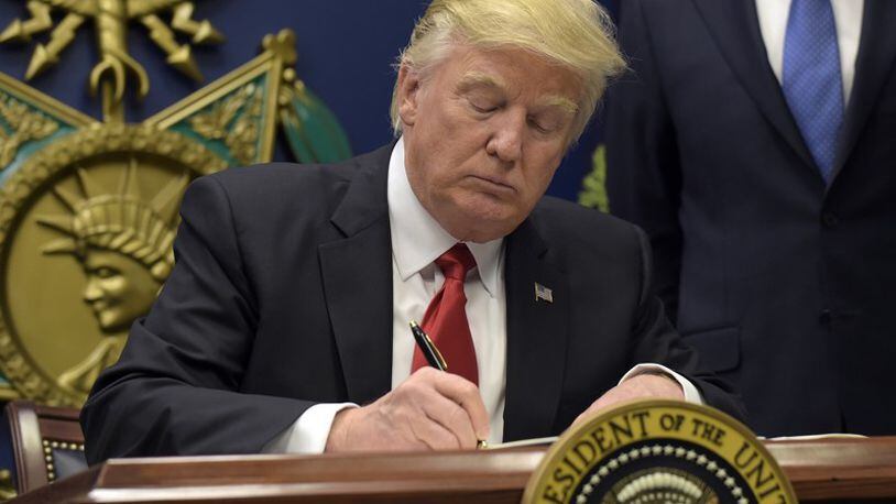 President Donald Trump signs an executive order on extreme vetting during an event at the Pentagon in Washington, Friday, Jan. 27, 2017. (AP Photo/Susan Walsh)
