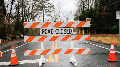 12/28/2018 -- Roswell, Georgia -- A road closure sign deters drivers from traveling along flooded Azalea Road in Roswell, Friday, December 28, 2018. Azalea Drive, between Willeo Road and Riverside Drive, was closed off to cars Friday after persistent rain fell the night before causing significant flooding along the Chattahoochee River.  (ALYSSA POINTER/ALYSSA.POINTER@AJC.COM)