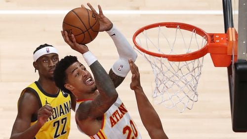 Hawks forward John Collins grabs the offensive rebound and goes to the board against the Indiana Pacers Sunday, April 18, 2021, at State Farm Arena in Atlanta. (Curtis Compton / Curtis.Compton@ajc.com)
