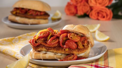 A saute of tomatoes, yellow bell peppers and cherry peppers bolsters the crisp breaded cutlet in this chicken Parmesan sandwich. (Zbigniew Bzdak/Chicago Tribune/TNS)