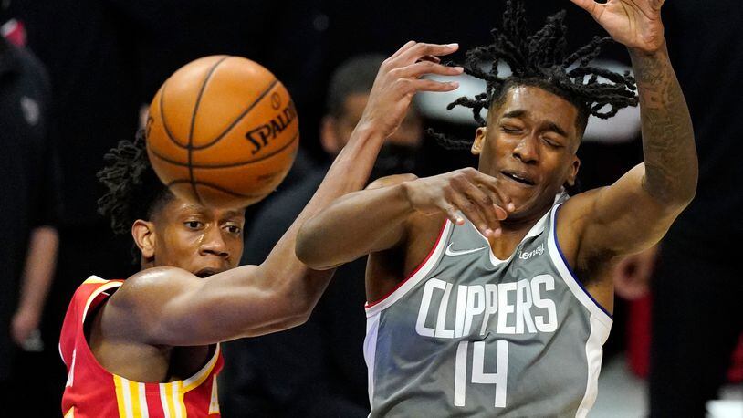 Hawks forward De'Andre Hunter and Los Angeles Clippers guard Terance Mann go after a rebound during the first half of Monday's game in Los Angeles.