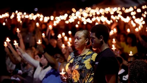 Veronica Hartfield, stands with her son, Ayzayah Hartfield during a candlelight vigil for her husband, Las Vegas police officer Charleston Hartfield, Thursday, Oct. 5, 2017, in Las Vegas. Hartfield was killed during the Sunday night shooting at the Route 91 Harvest country music festival. (AP Photo/Gregory Bull)