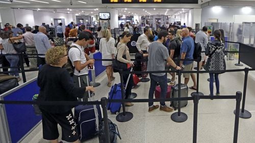 Travelers stand in line to pass through a TSA checkpoint at Miami International Airport on Thursday. (AP Photo/Alan Diaz)