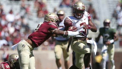 Florida State’s Cam Akers tries to break away from Stanford Samuels III during the NCAA college football team’s Garnet and Gold spring game in Tallahassee, Fla., Saturday, April 8, 2017. (Joe Rondone/Tallahassee Democrat via AP)