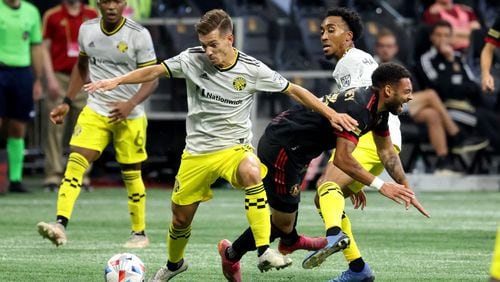 Atlanta United midfielder Jake Mulraney (23) is fouled on the play by Columbus Crew forward Pedro Santos (7, left) and midfielder Marlon Hairston (17) during the first half Saturday, July 24, 2021, at Mercedes Benz Stadium in Atlanta. (Jason Getz/For the AJC)