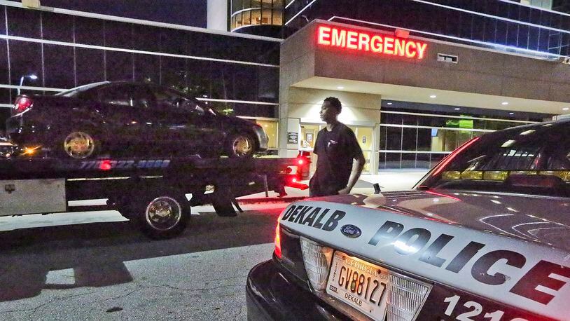 A car is towed from DeKalb Medical Hillendale after three shooting victims arrived at the hospital early Friday. JOHN SPINK / JSPINK@AJC.COM