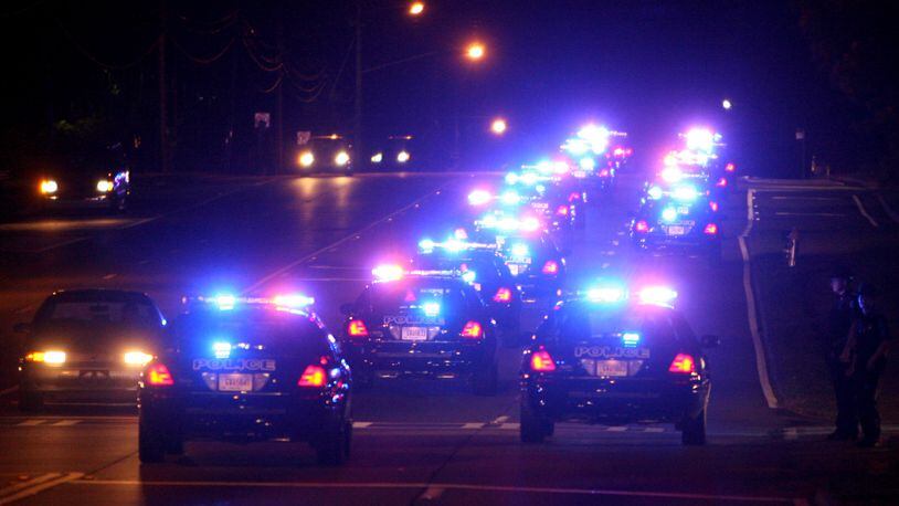 Sandy Springs police cars, travel south on Roswell Road during a ceremonial changing of the guard at midnight following a reception launching Sandy Springs’ new police department June 30, 2006. (Brant Sanderlin/AJC staff)