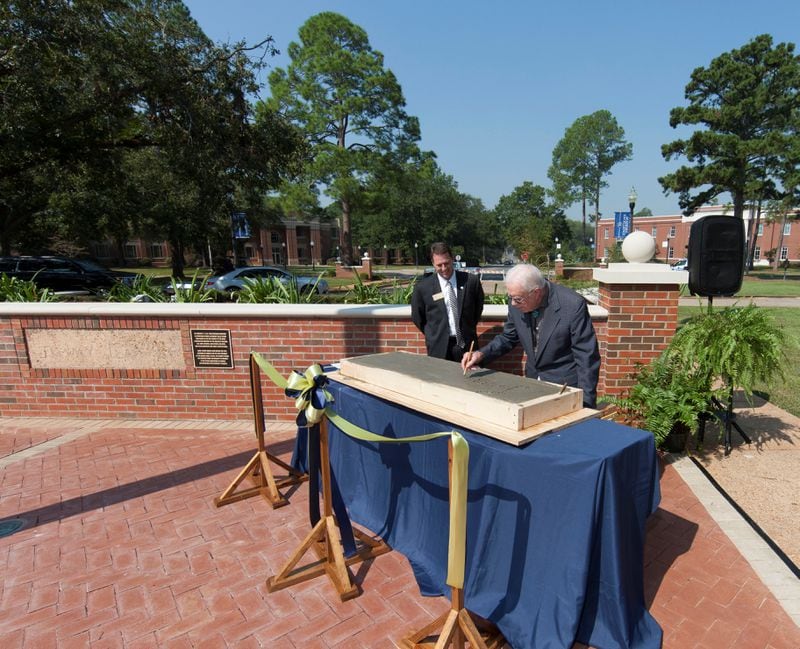 Georgia Southwestern State University President Neal Weaver, left, looks on as former President Jimmy Carter signs his name in wet concrete at the 2017 Presidential Plaza dedication. PHOTO CONTRIBUTED
