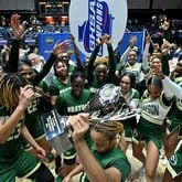 Grayson's Malaya Jones (front) holds the championship trophy and celebrates with teammates and cheerleaders after the team's 65-44 victory over North Paulding Saturday in the Class 7A girls title game.  (Hyosub Shin / Hyosub.Shin@ajc.com)