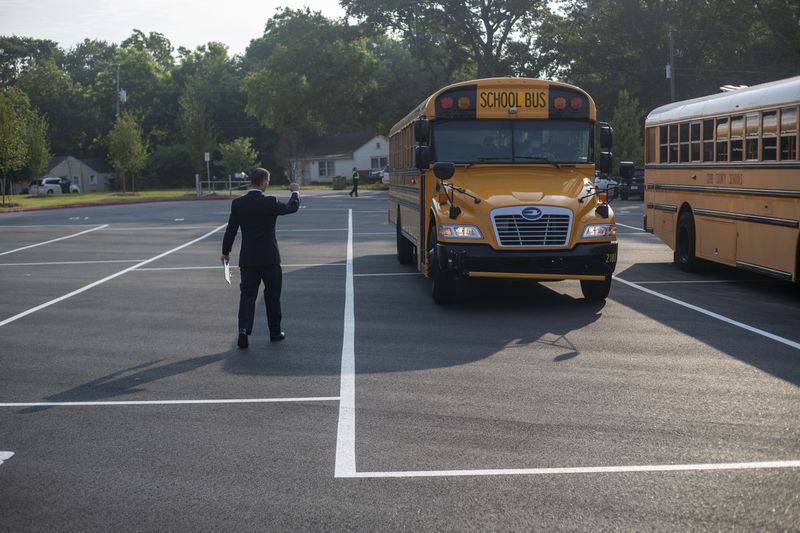  Pearson Middle School Senior Assistant Principal Mitchell Askew directs school busses to their parking spot during the first day of school at Pearson Middle School in Marietta, Monday, August 2, 2021. (Alyssa Pointer/Atlanta Journal Constitution)