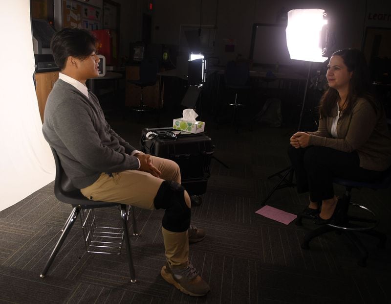 Hau Vo, 16, an 11th-grader from Vietnam (left), is interviewed by Tea Rozman Clark, the executive director of Green Card Voices, about his immigration experiences for the book “Green Card Youth Voices” at Cross Keys High School in Atlanta on Nov. 10, 2017.  (Photo: Rebecca Breyer / Special to the AJC)