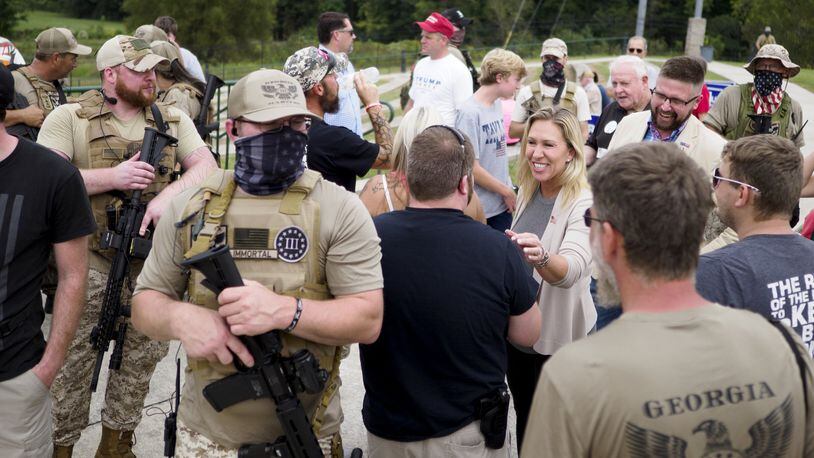 Armed members of the Georgia III% Martyrs surround Marjorie Taylor Greene as she meets with supporters during a Second Aamendment rally at the Northwest Georgia Amphitheatre on Saturday, Sept. 19, 2020, in Ringgold, Ga. Photo by C.B. Schmelter/Times Free Press