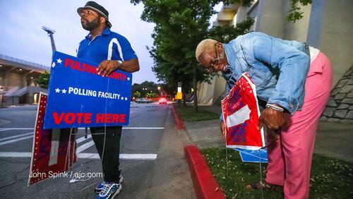 Poll workers Chris Nolan (left) and Raphallia Edwards  set up outside Grady High School.