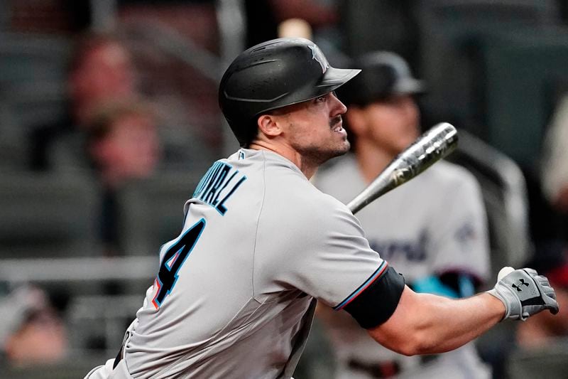 Miami Marlins' Adam Duvall (14) watches his three-run home run during the seventh inning of a baseball game against the Atlanta Braves on Tuesday, April 13, 2021, in Atlanta. (AP Photo/John Bazemore)