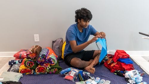 Akhil Kalva (age 15) fills "buddy packages" with clothes, toiletries and other items for children in foster care at his Johns Creek home. Phil Skinner for The Atlanta Journal-Constitution.