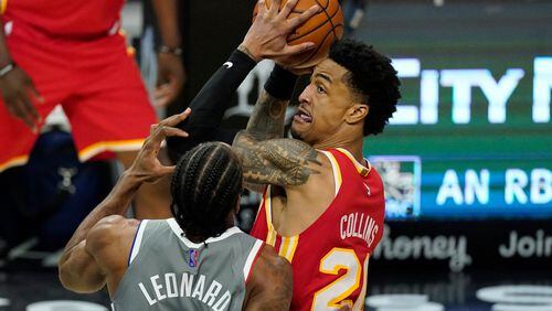 Atlanta Hawks forward John Collins, tries to pass while under pressure from Los Angeles Clippers forward Kawhi Leonard during the second half of an NBA basketball game Monday, March 22, 2021, in Los Angeles. The Clippers won 119-110. (AP Photo/Mark J. Terrill)