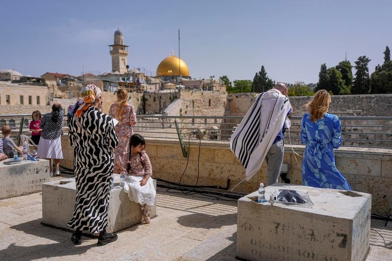 Jews participate in the Cohanim Priestly caste blessing during the holiday of Passover, overlooking the Western Wall, the holiest site where Jews can pray, with the golden Dome of the Rock in the background, in Jerusalem's Old City, Thursday, April 25, 2024. The Cohanim, believed to be descendants of priests who served God in the Jewish Temple before it was destroyed, perform a blessing ceremony of the Jewish people three times a year during the festivals of Passover, Shavuot and Sukkot. (AP Photo/Ohad Zwigenberg)