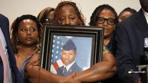 Mika Fortson, mother of Roger Fortson, a U.S. Navy airman, holds a photo of her son during a news conference with Attorney Ben Crump, Thursday, May 9, 2024, in Ft. Walton Beach, Fla. Fortson was shot and killed by police in his apartment on May 3, 2024. (AP Photo/Gerald Herbert)