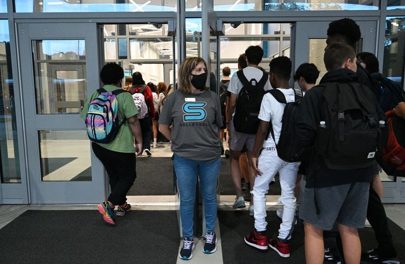 Staff member Jejna Mujkic greets students arriving for the first day of school at Seckinger High School in Buford on Wednesday, August 3, 2022. (Hyosub Shin / Hyosub.Shin@ajc.com)