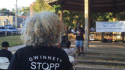 Gwinnett SToPP advisory board member Marlyn Tillman, in the black T-shirt, listens as fellow member Penny Poole speaks at the group’s rally Monday afternoon. ERIC STIRGUS/STAFF