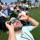 Tyler Steel, of Acworth, uses eclipse glasses to view the solar eclipse on the 18th green during the practice round of the 2024 Masters Tournament at Augusta National Golf Club, Monday, April 8, 2024, in Augusta, Ga. (Jason Getz / jason.getz@ajc.com)