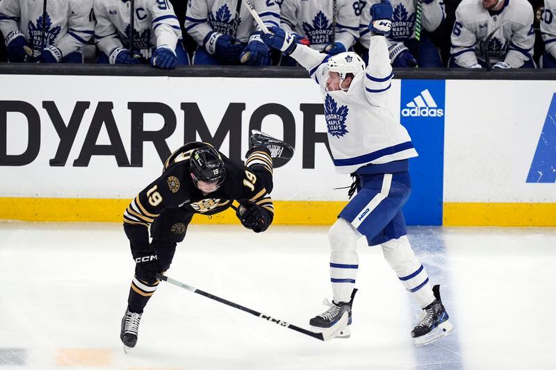Toronto Maple Leafs' Simon Benoit, right, checks Boston Bruins' John Beecher (19) during the first period of Game 7 of an NHL hockey Stanley Cup first-round playoff series, Saturday, May 4, 2024, in Boston. (AP Photo/Michael Dwyer)