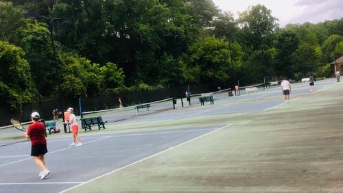 The five tennis courts at Decatur’s Glenlake Park were mostly full Tuesday night, one day after the reopening of all nine city-owned parks. Bill Banks for the AJC