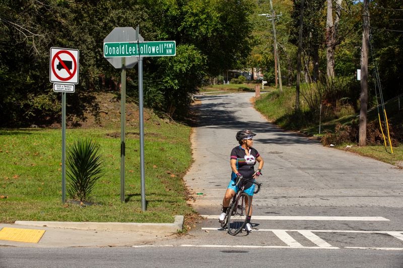Rolanda Powell waits to merge onto Donald Lee Hollowell Parkway from Center Hill Avenue. Powell is the head of her neighborhood organization and often bikes on Hollowell. (Photo/Rebecca Wright for the Atlanta Journal-Constitution)