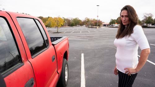 Rebekah Wilson said she was scammed out of $4,000 she paid for a down payment for a car from a program that claimed to be a nonprofit that helps adults in recovery obtain reliable vehicles. She never received the promised vehicle and still relies on her old red truck seen here in a parking lot outside an Athens shopping mall. (Olivia Bowdoin for The Atlanta Journal-Constitution)