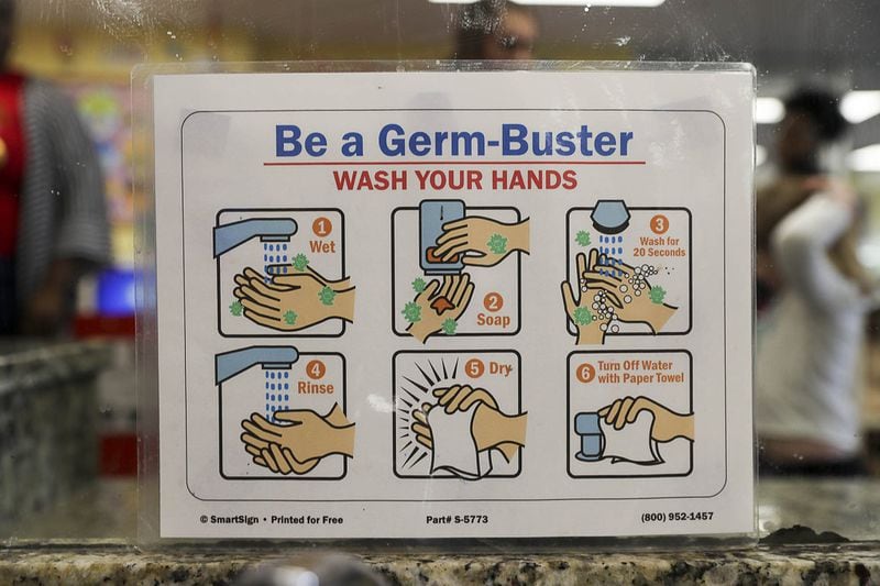 In this file photo, a hand-washing instruction sign is displayed near the sinks for students at the Kids R Kids Learning Academy day care center in Marietta. ALYSSA POINTER / ALYSSA.POINTER@AJC.COM