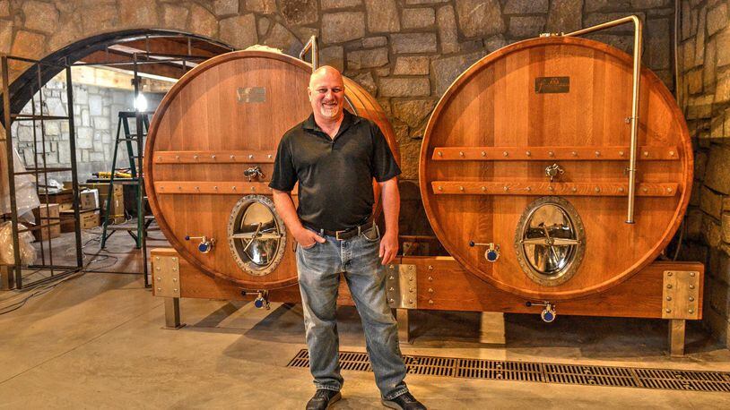 John “JR” Roberts, brewmaster at Bold Monk Brewing Co., stands in front of two oak foeders in the cask room. CONTRIBUTED BY CHRIS HUNT PHOTOGRAPHY
