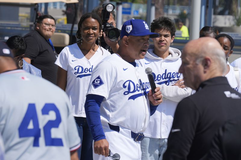 Los Angeles Dodgers manager Dave Roberts, center, introduces Ayo Robinson, rear left, the granddaughter of baseball legend Jackie Robinson, as Dodgers and Washington Nationals team members join in a celebration for Jackie Robinson Tribute Day before a baseball game at Dodgers Stadium in Los Angeles on Monday, April 15, 2024. (AP Photo/Damian Dovarganes)