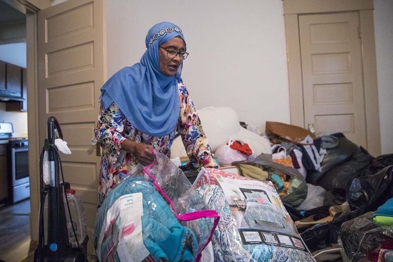 Osman goes through donated items she collected for refugees at her residence in Clarkston. ALYSSA POINTER/ALYSSA.POINTER@AJC.COM